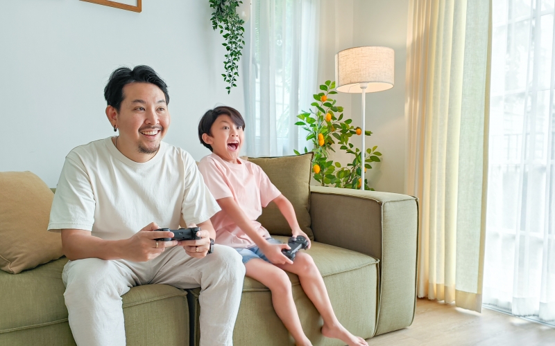 un parent et son enfant jouent à un jeu vidéo